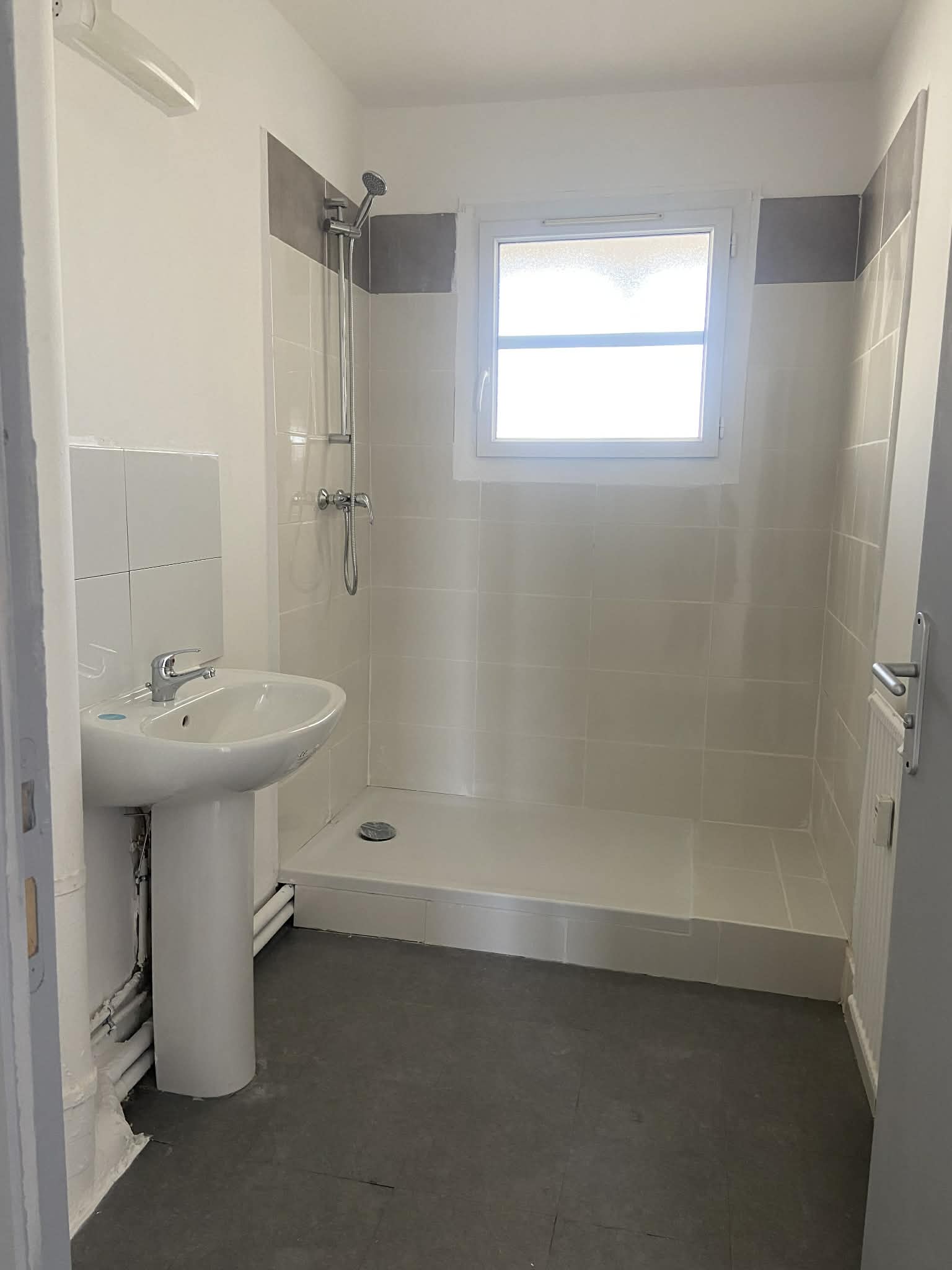 Salle de bain terminée — carrelage posé et douche installée